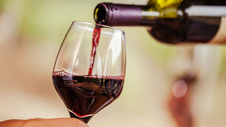 Pouring red wine into wine glass at a local South Coast Winery/Vinyard
