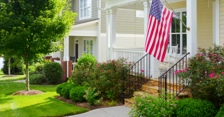Well kept front lawn, with green grass and American flag