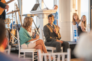 A Sunshine Kid on stage with Maria Stephanos at Robert Paul Properties’ Annual Sunshine Soiree at Wychmere Beach Club in Harwich Port, benefiting the Sunshine Kids Foundation.
