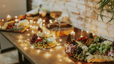 A decorated table for a holiday party with appetizers and string lights