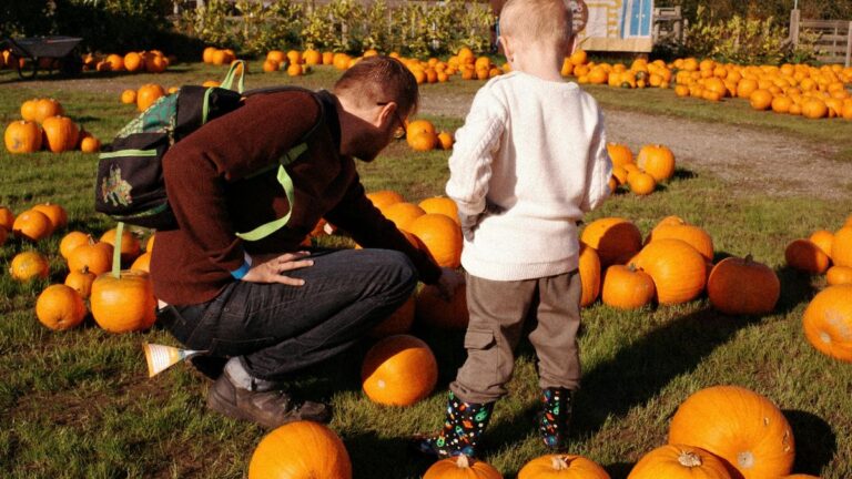 Pumpkin patch at a Greater Boston farm, featuring a father and son picking out a pumpkin together