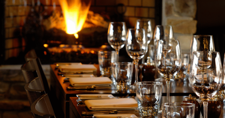 Restaurant table set for a large party by a cozy fireplace