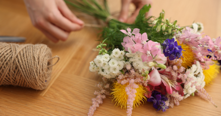 florist tying bouquet with twine handmade floral arrangement
