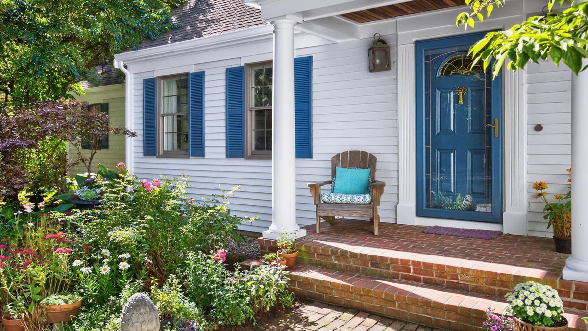 Cape Cod cottage front entry with blue door and garden