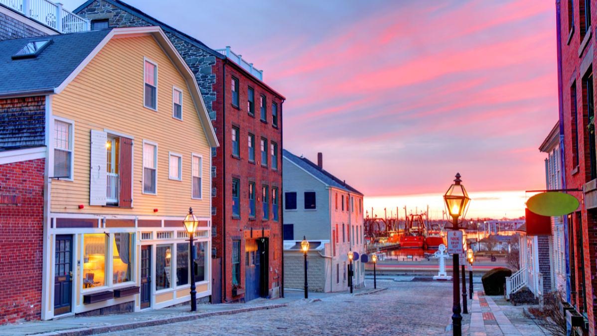 New Bedford historic cobblestone street ending at the harbor with a vivid sunset
