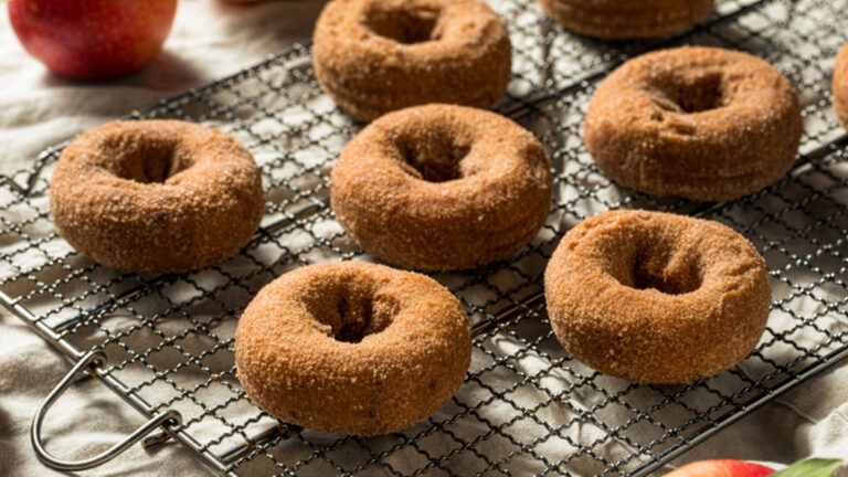 Fresh apple cider donuts cooling on a wire rack