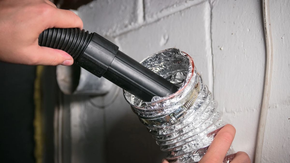 Cleaning lint from a flexible dryer vent hose with a vacuum attachment