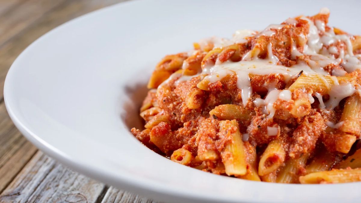 Penne pasta with a rich tomato meat sauce and grated cheese